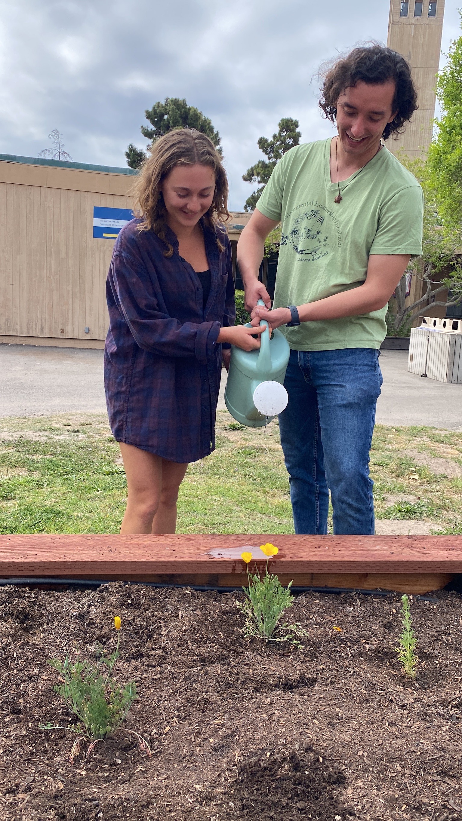 Emily and Tanner tend to newly planted garden