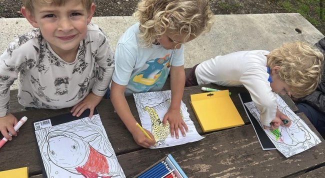 Three young kids engaged in an environmental education activity.