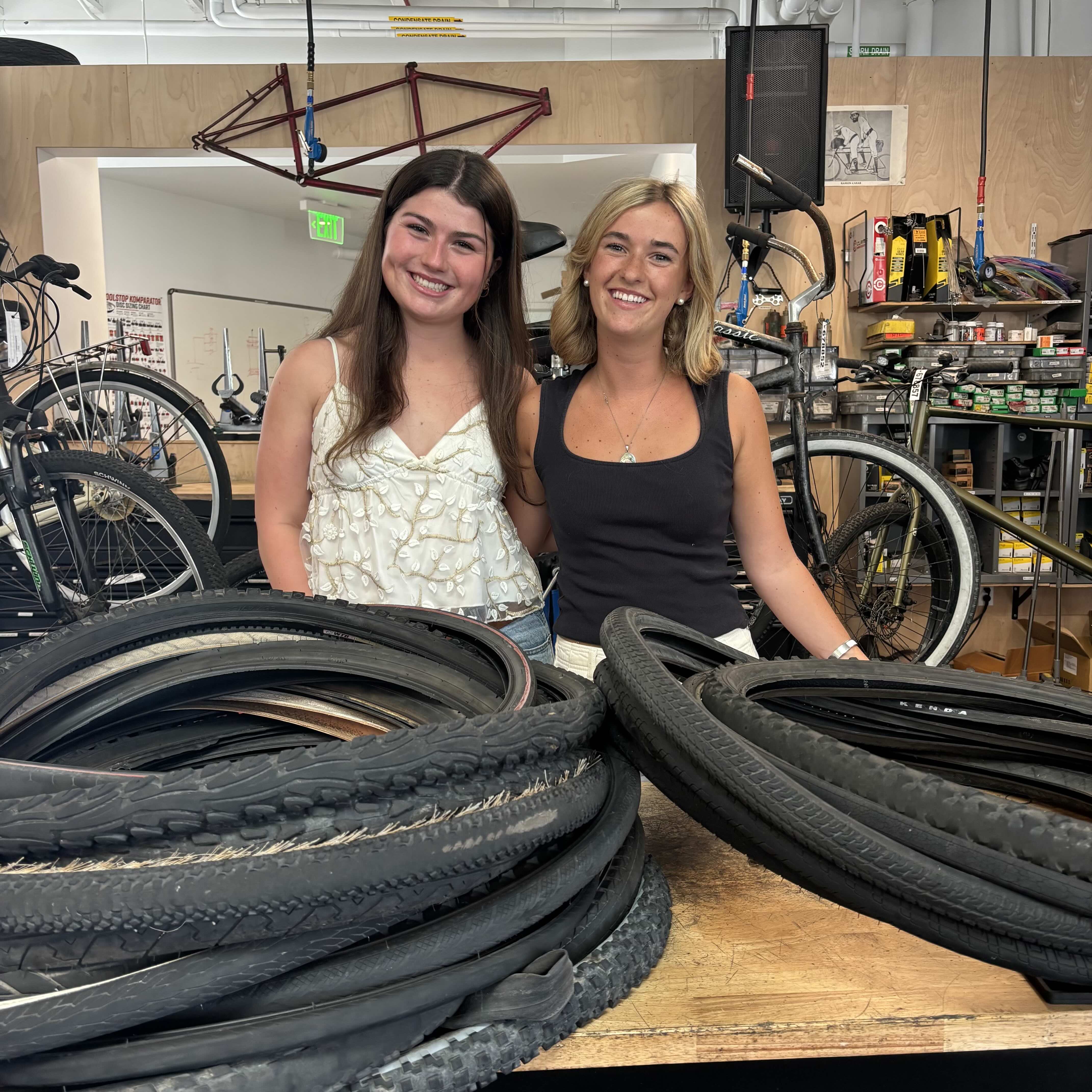 Sophia and Virginia in front of bike tires - TREAD project